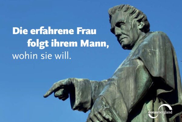 Donaubergland Postkartenmotiv mit Statue mit ausgestrecktem Zeigefinger.