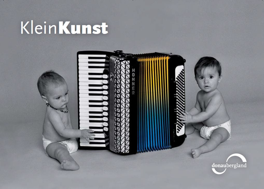 Donaubergland Postkartenmotiv mit zwei Babys, die ein Hohne Akkordeon abtasten.