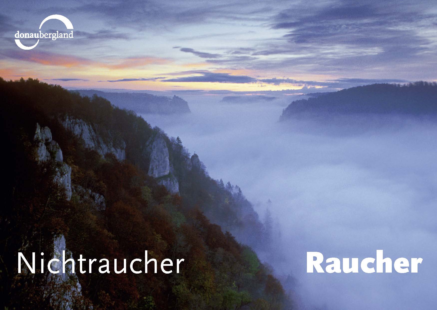 Donaubergland Postkartenmotiv mit Blick in ein nebelverhangenes Tal in Blautönen und im Hintergrund ist der Himmel rötlich verfärbt.