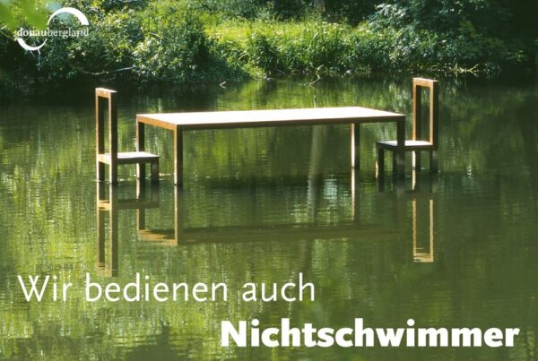 Donaubergland Postkartenmotiv mit großem Tisch und zwei Stühlen in einem Gewässer