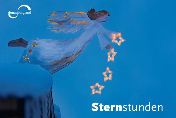 Donaubergland Postkartenmotiv mit Engel auf blauem Hintergrund mit vier beleuchteten Sternen, die aus dem Arm fallen.