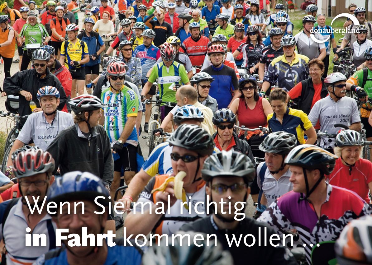 Donaubergland Postkartenmotiv mit ganz vielen Fahrradfahrern mit bunten Trikots