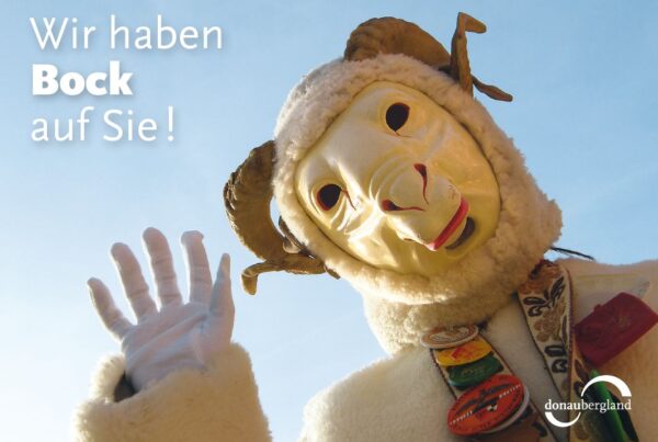 Donaubergland Postkartenmotiv mit einem winkenden Narr mit Bock-Maske.