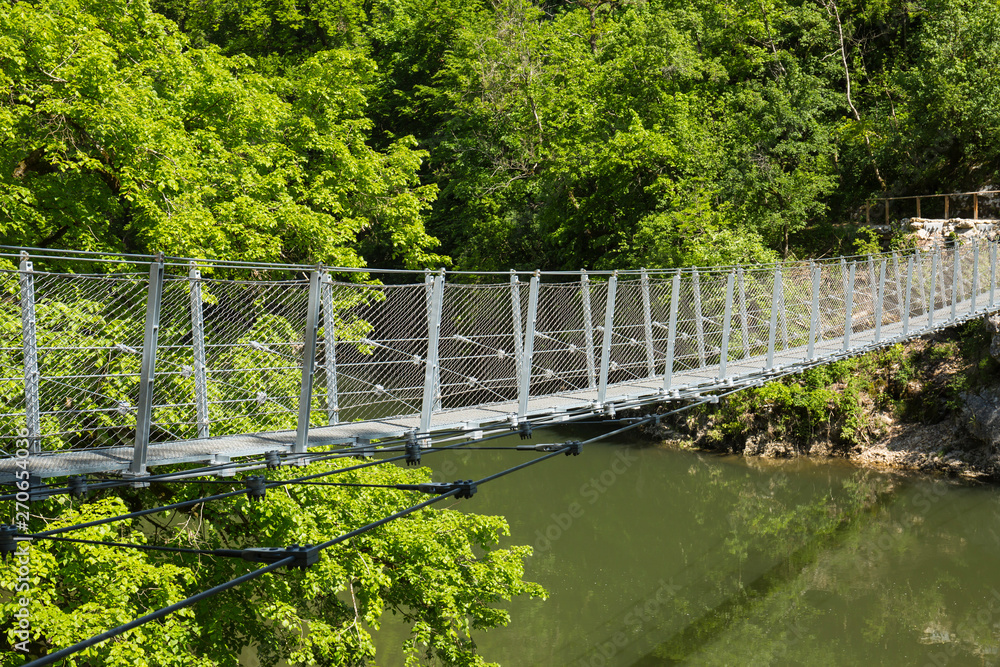 Bild von Hängebrücke über Wasser mit Bäumen umgeben